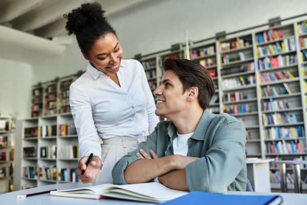 Engaging discussion between a student and mentor in a vibrant library setting